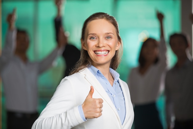 Free Photo smiling broadly business woman showing thumb up