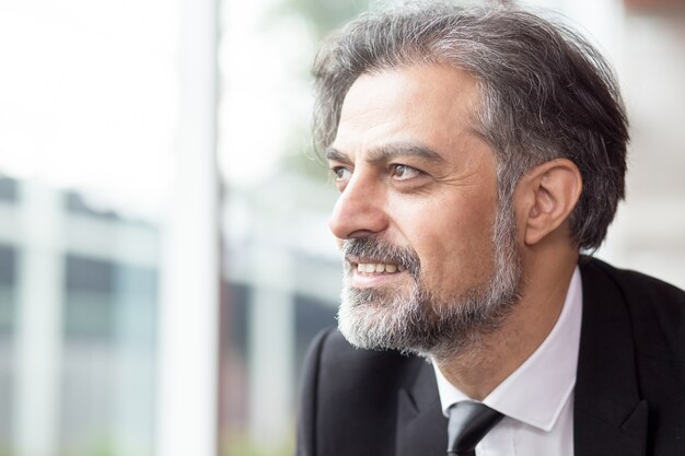 Smiling Business Leader Looking Through Window