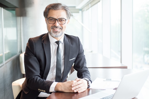 Smiling Business Leader Sitting at Office Desk