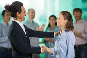 Free photo smiling business man congratulating colleague