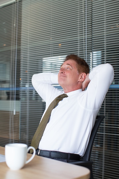 Smiling Business Man Relaxing at Office Desk