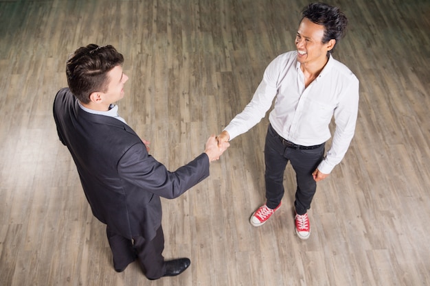 Free photo smiling business men meeting and shaking hands