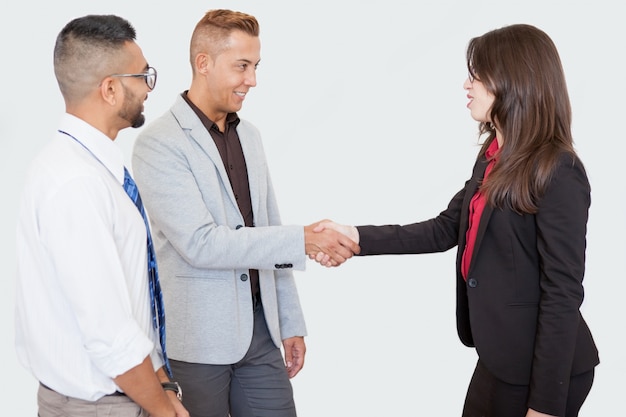 Free photo smiling business people shaking hands at meeting