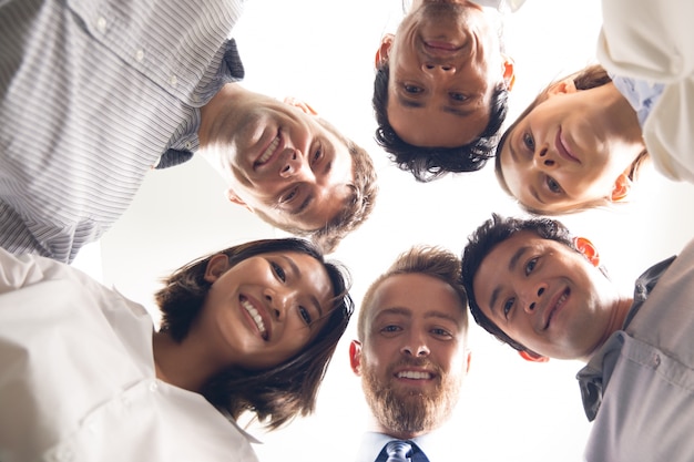 Free photo smiling business people with their heads together