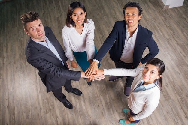 Free Photo smiling business team with hands together in hall