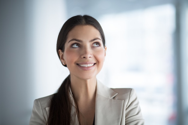 Free Photo smiling business woman looking up at copy space