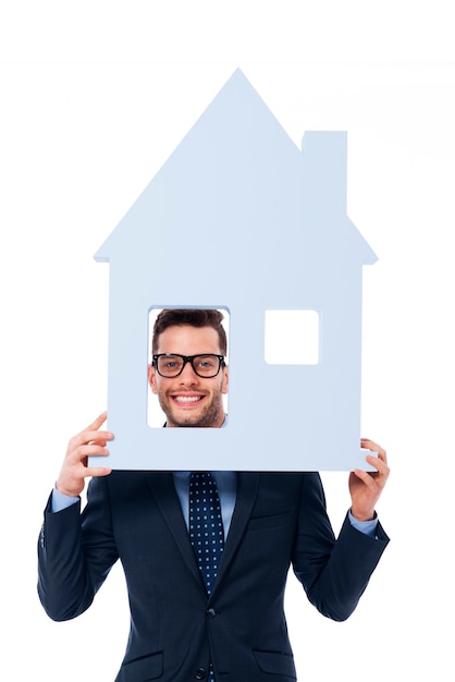 Free Photo smiling businessman holding house sign