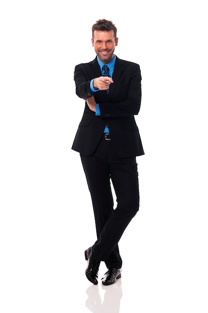 Free photo smiling businessman pointing at camera side