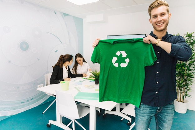 Free photo smiling businessman showing green t-shirt with recycle symbol