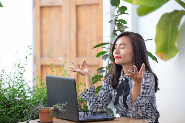 Smiling businesswoman shows gestures to meditate