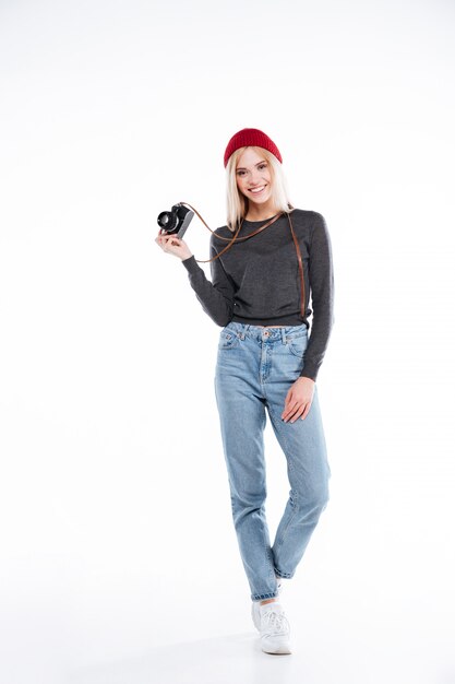 Smiling casual woman photographer standing and holding retro camera