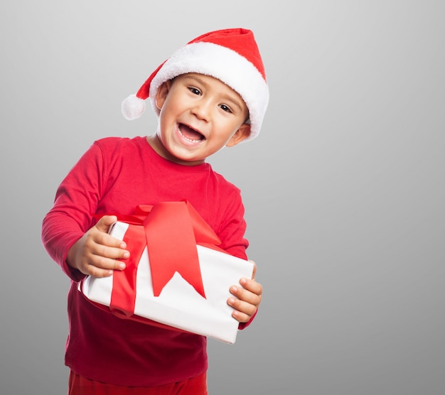 Smiling child holding a gift with decorative ribbon