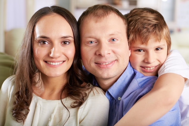 Free photo smiling child hugging their parents