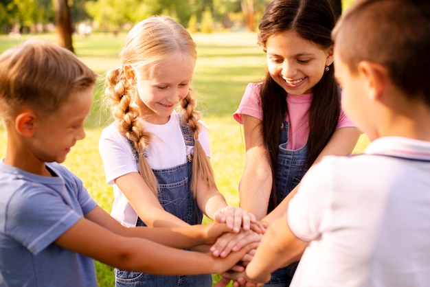 Free Photo smiling children putting their hands together