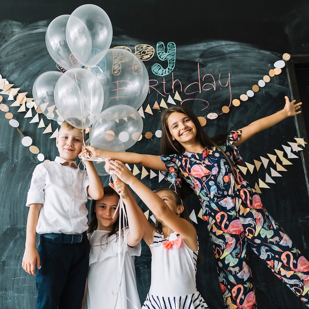 Smiling children with balloons on birthday party