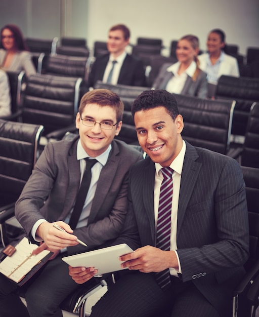 Free photo smiling co-workers looking at a tablet