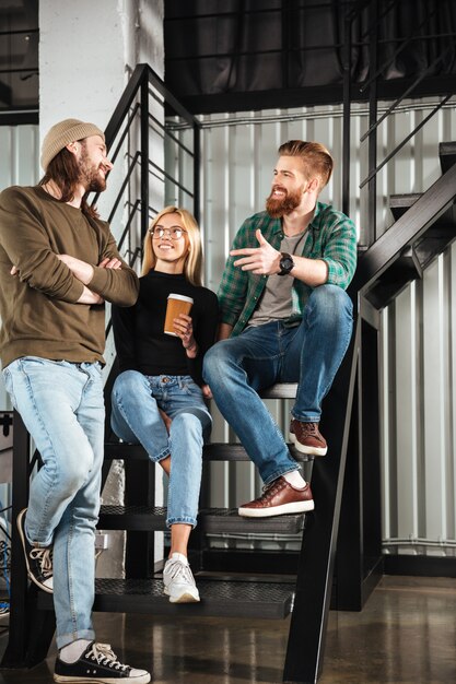 Smiling colleagues in office talking with each other