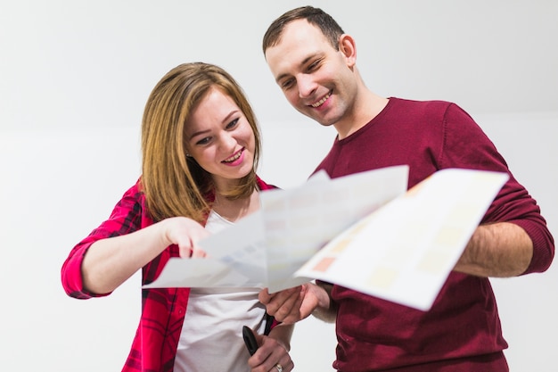 Free photo smiling couple choosing color for wall paint