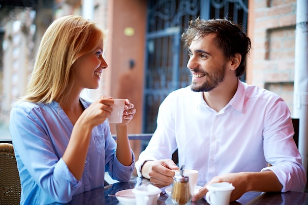 Free Photo smiling couple drinking coffee and looking at each other 