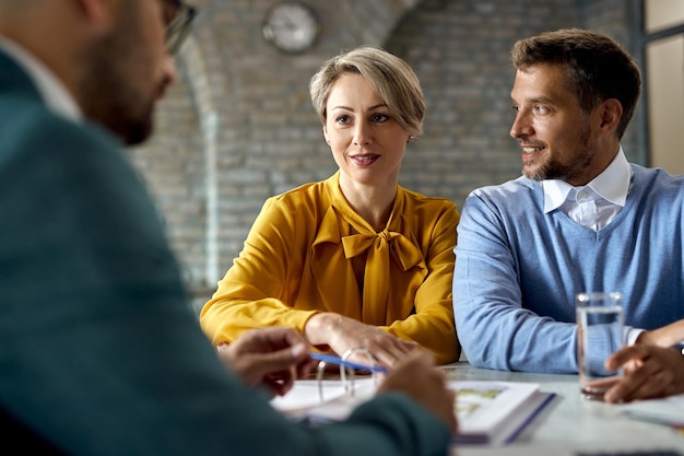 Free photo smiling couple having consultations with their financial advisor in the office