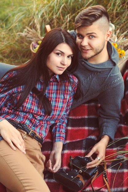 Smiling couple lying on a tablecloth outdoors