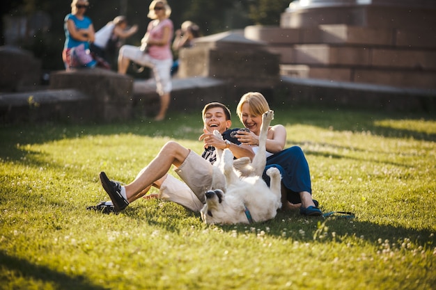 Smiling couple playing with their dog