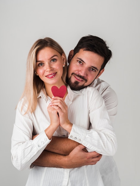 Free photo smiling couple posing with heart for valentines day