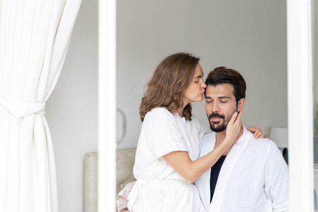 smiling couple relaxing and Couples cuddling and kiss forehead on bed