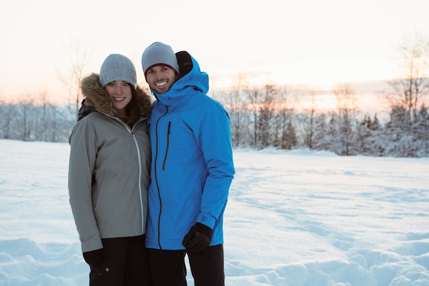 Smiling couple standing on snowy landscape