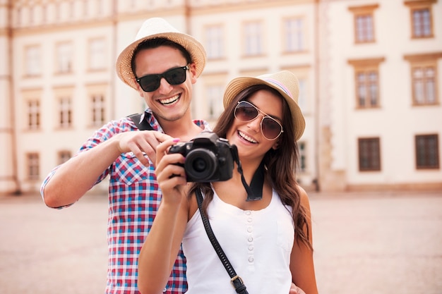 Free photo smiling couple viewing pictures on the camera