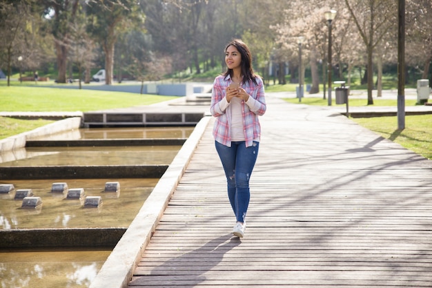 Smiling delighted girl enjoying landscape in city park