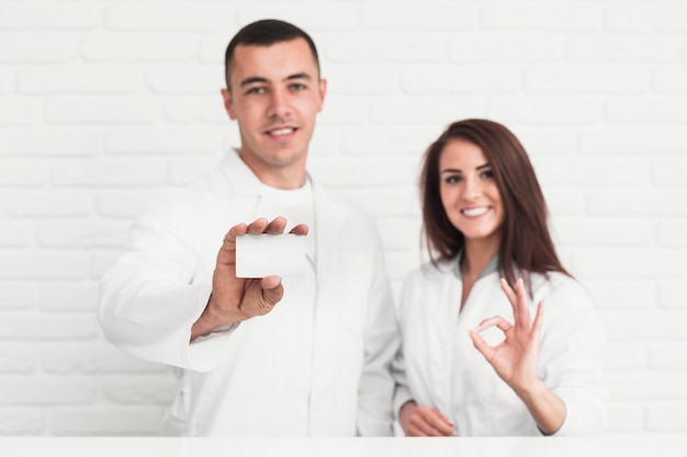 Smiling doctors showing ok sign and card mock up