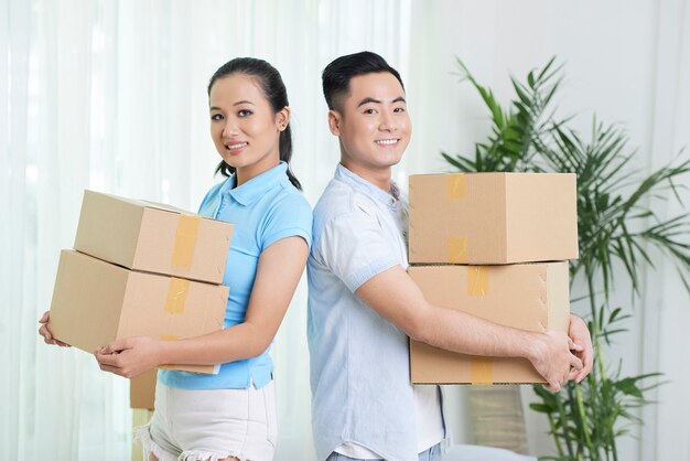 Smiling ethnic couple with carton boxes