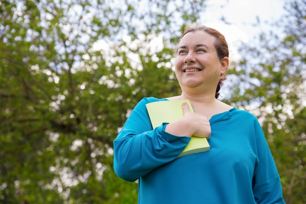 Smiling excited woman impressed with book story