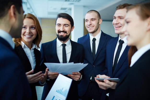 Free photo smiling executive holding some documents with workmates