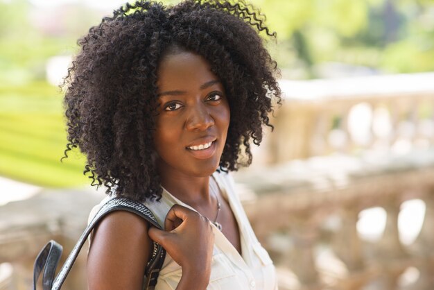 Smiling face of young woman carrying backpack