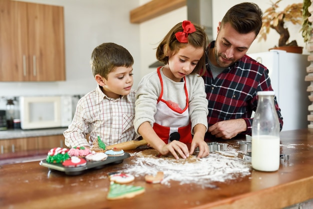 Smiling family decorating christmas cookies in the kitchen