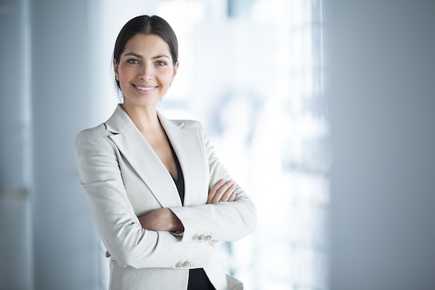 Free photo smiling female business leader with arms crossed