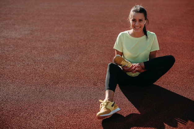 Smiling female doing flexibility exercises on fresh air