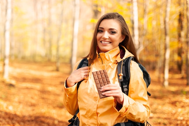 Free photo smiling female hiker with dark chocolate