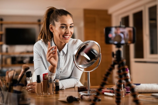 Smiling female influencer talking about beauty products while vlogging from home