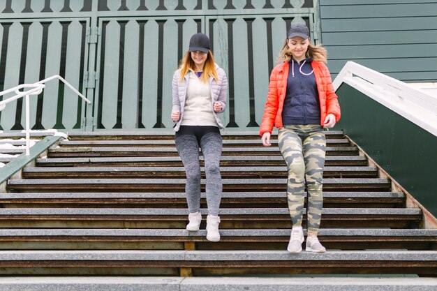 Smiling female jogger running on staircase