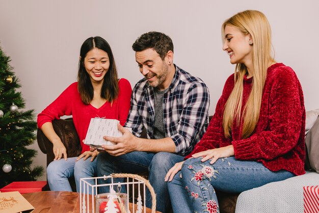 Smiling friends gifting each other