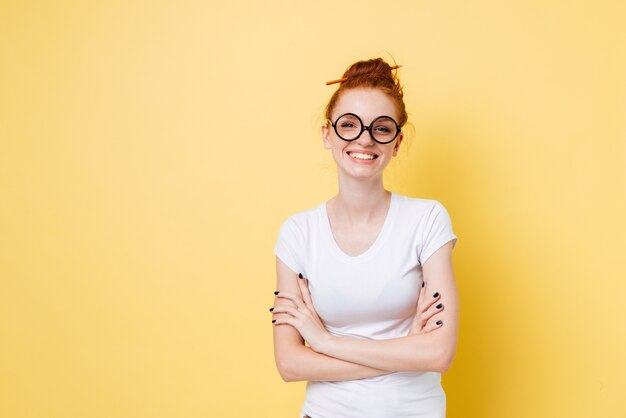 Smiling ginger woman in eyeglasses posing with crossed arms