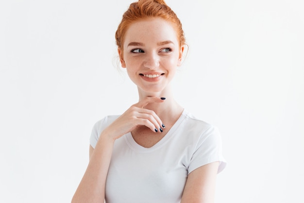 Smiling ginger woman in t-shirt looking away