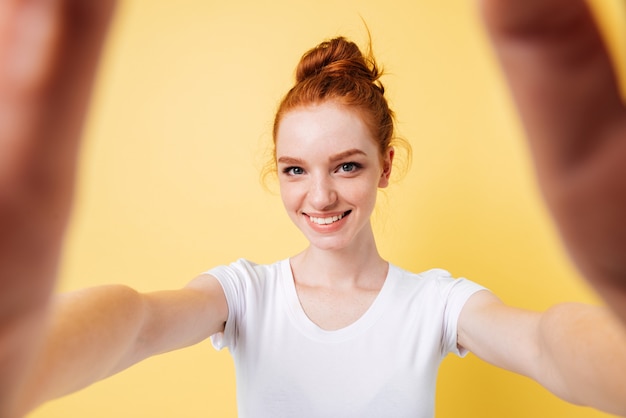 Free photo smiling ginger woman in t-shirt making selfie