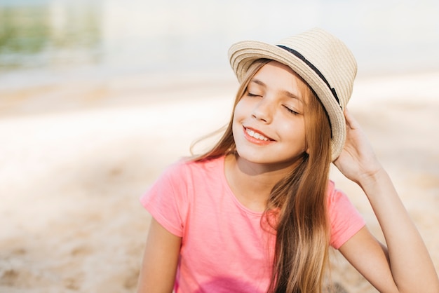 Smiling girl in hat enjoying sunshine