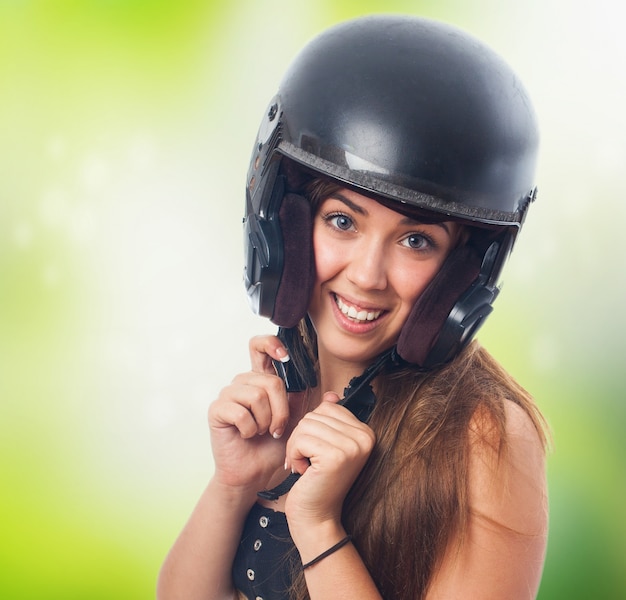 Free photo smiling girl holding black helmet on head.