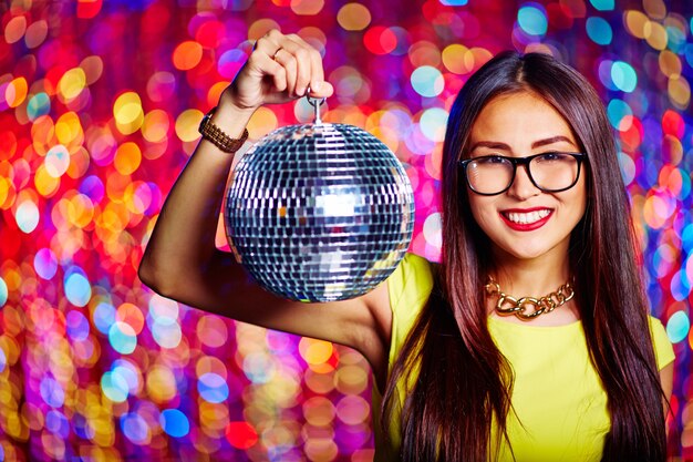 Smiling girl holding a mirror ball