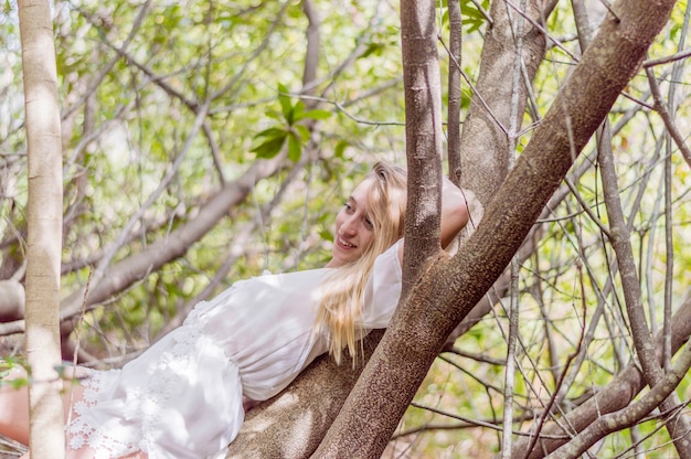 Free photo smiling girl lying on a tree